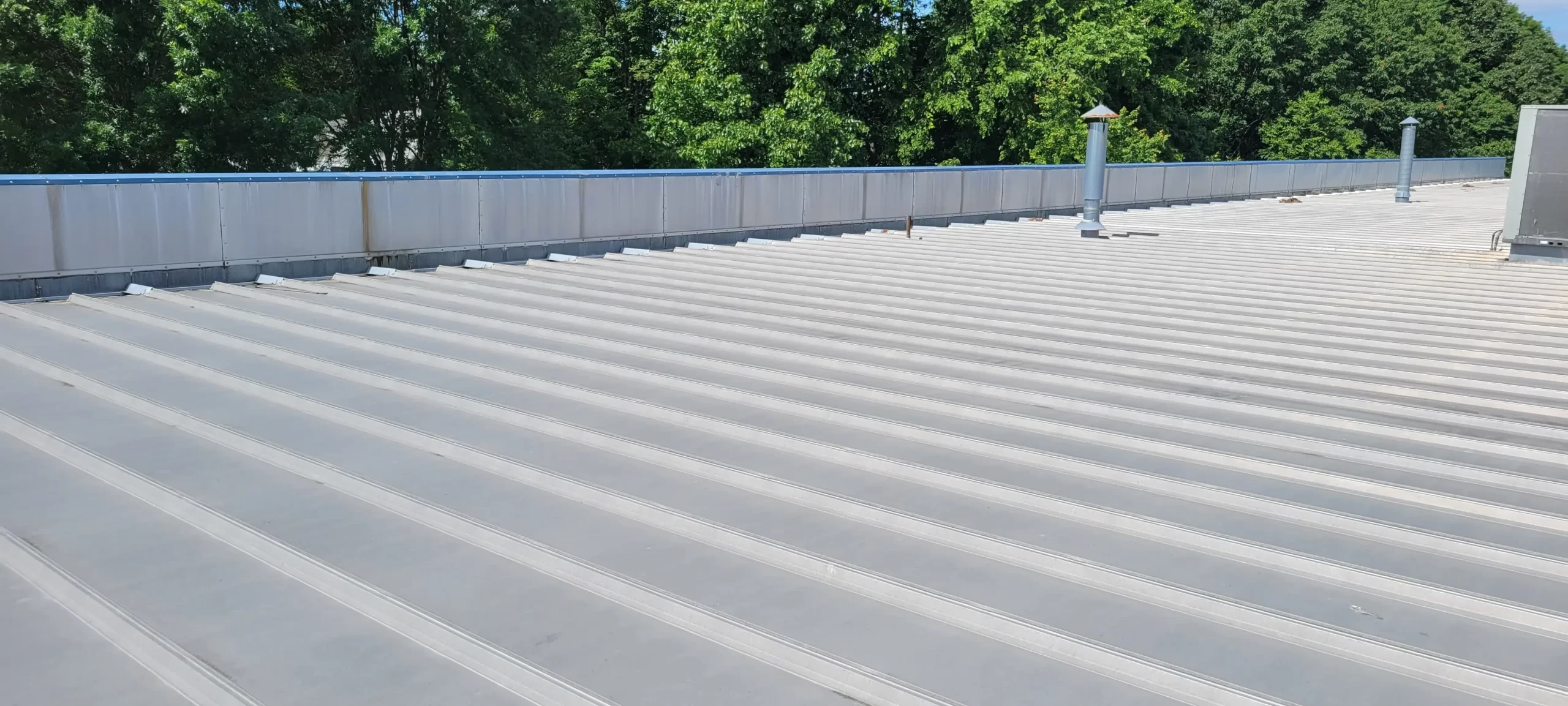 Metal roof inspection with parapet walls in Chicopee, MA.